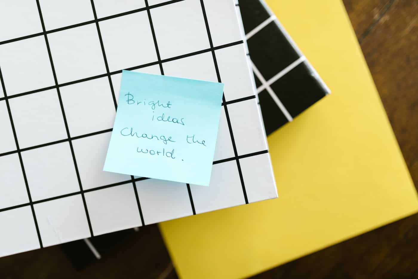 Bright ideas Change the world sticky note on gridded box